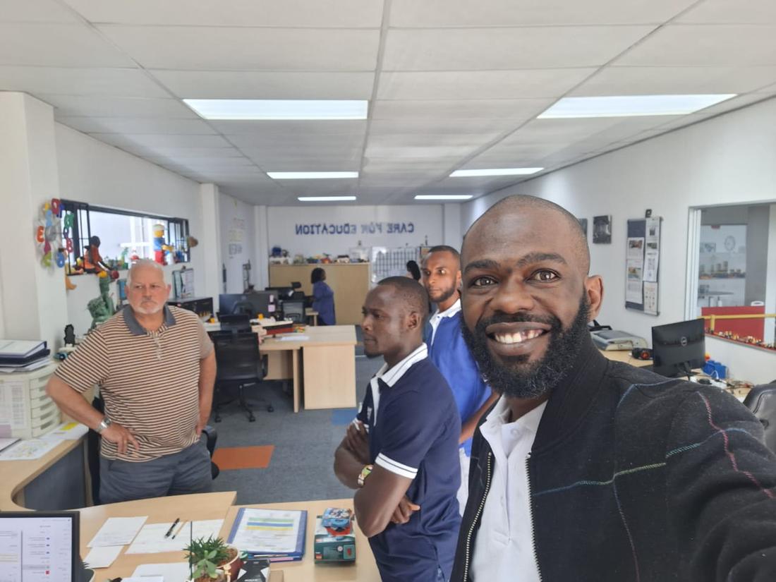 Four members of the team in an office full of play materials, one taking the selfie
