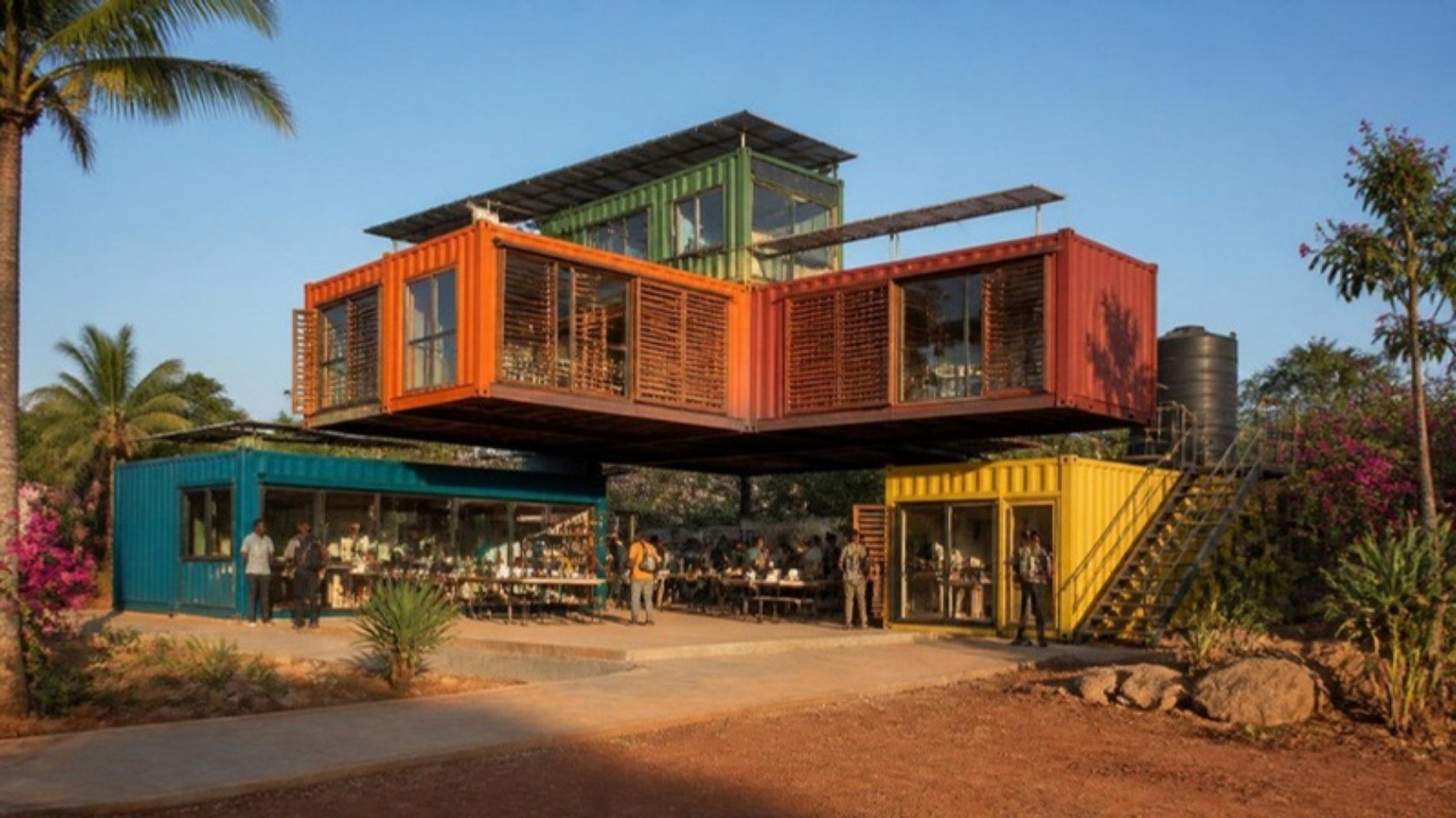 Concept render of five colourful stacked shipping containers forming an L around a shaded community courtyard with palm trees